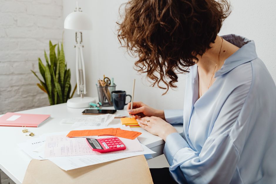 Dirigeante de TPE faisant le point sur ses chiffres avec une calculatrice